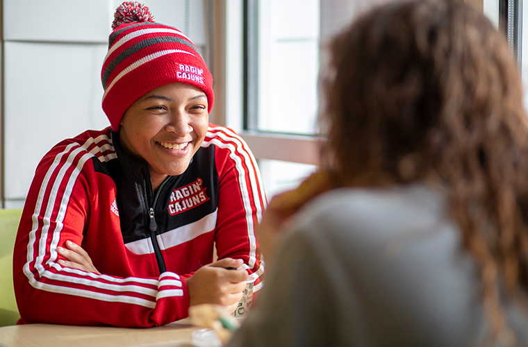 students having a conversation at a table in a university cafe