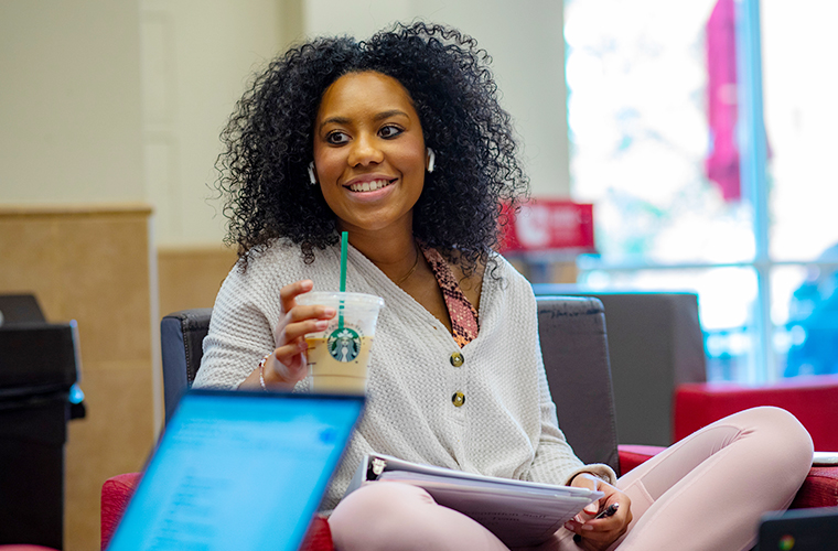 student drinking coffee with a friend at the university's starbucks location