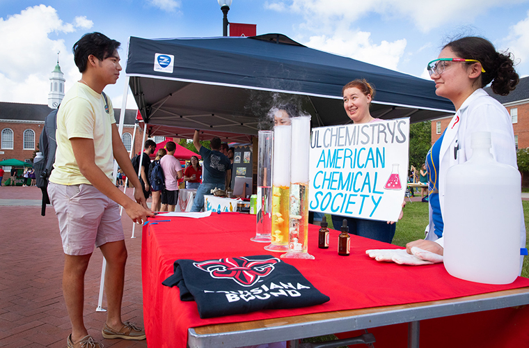 students at get on board day speaking to another student about the american chemical society