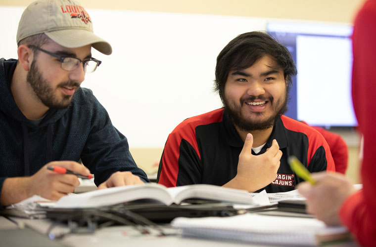 Two University of Louisiana at Lafayette students sitting at a table and having a discussion