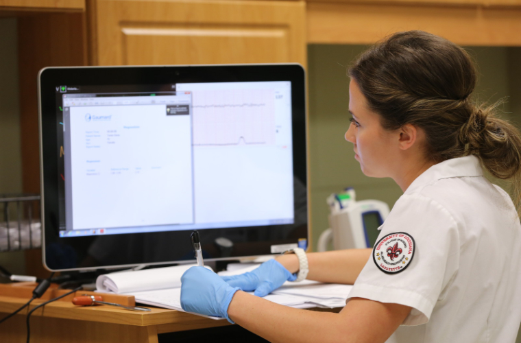 Health professional sits at computer