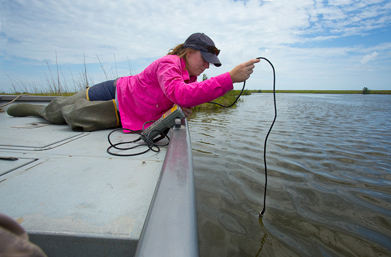 Student tasting water from boat