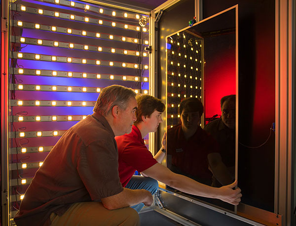 UL Lafayette researcher and Louisiana student examining a solar panel for sustainable energy research