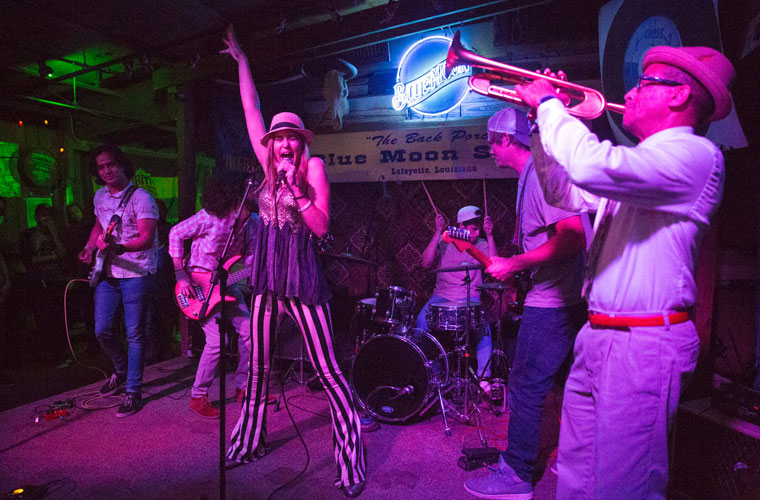 A University of Louisiana at Lafayette music major performing on stage at a music venue in Downtown Lafayette