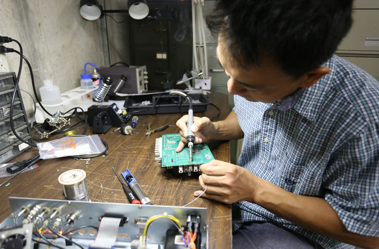 A physics researcher repairs a computer motherboard in a lab at the University of Louisiana at Lafayette