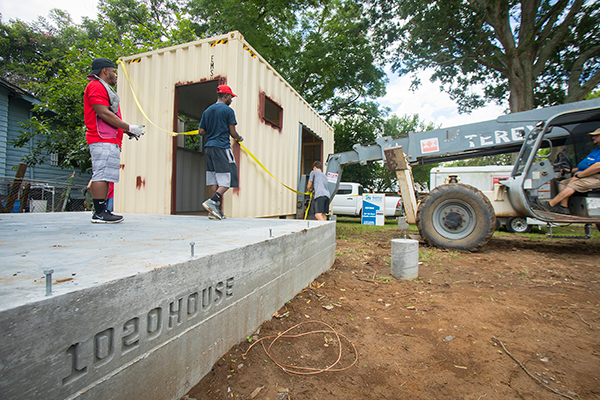 UL Lafayette architecture students guide a section of the 1020 House into place
