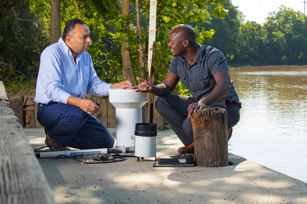 Dr. Emad Habib (left) and Dr. Robert Miller of the University’s Louisiana Watershed Flood Center by the Vermilion River.