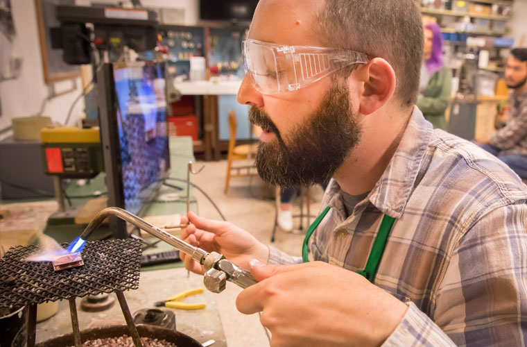 A metalworking and jewelry student at the University of Louisiana at Lafayette demonstrates on the jewelry bench