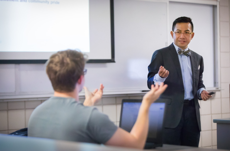 A student and professor having a discussion in class at the University of Louisiana at Lafayette.