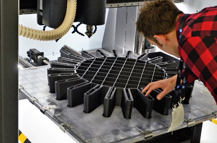 University of Louisiana at Lafayette mechanical engineering alum, Clay Guillory inspecting a 3D priced piece for his company, Titan Robotics.