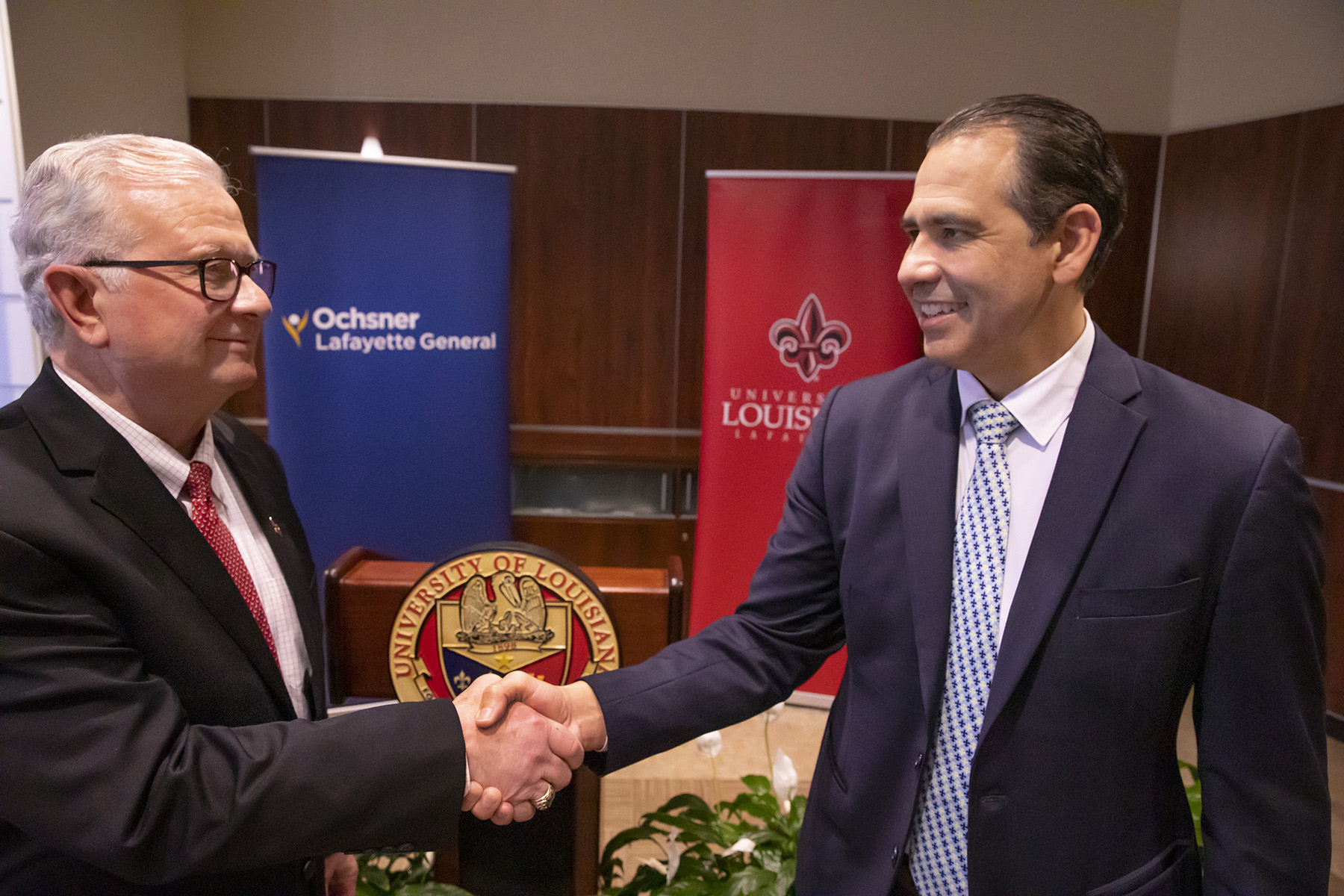 Speakers shake hands following press announcement