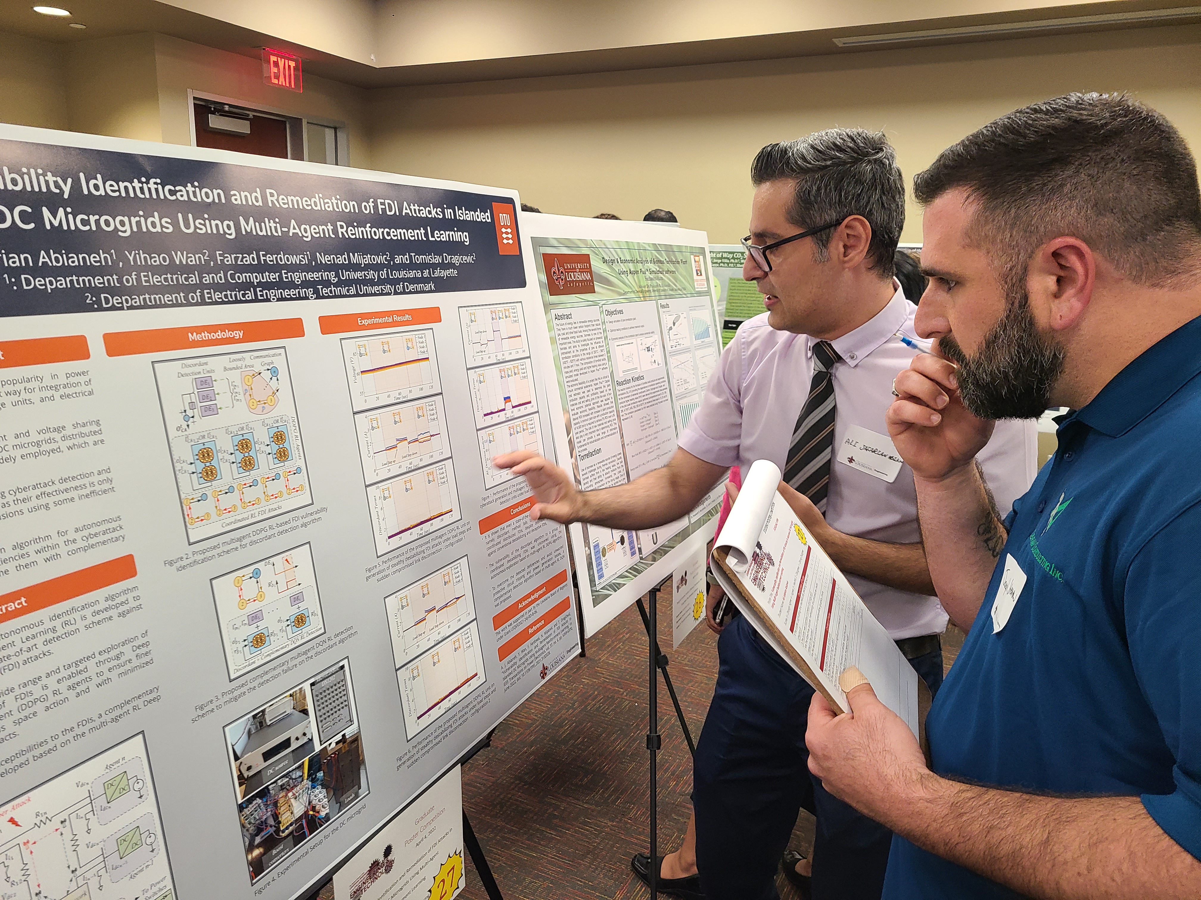Electrical Engineers showcasing a project board at a conference