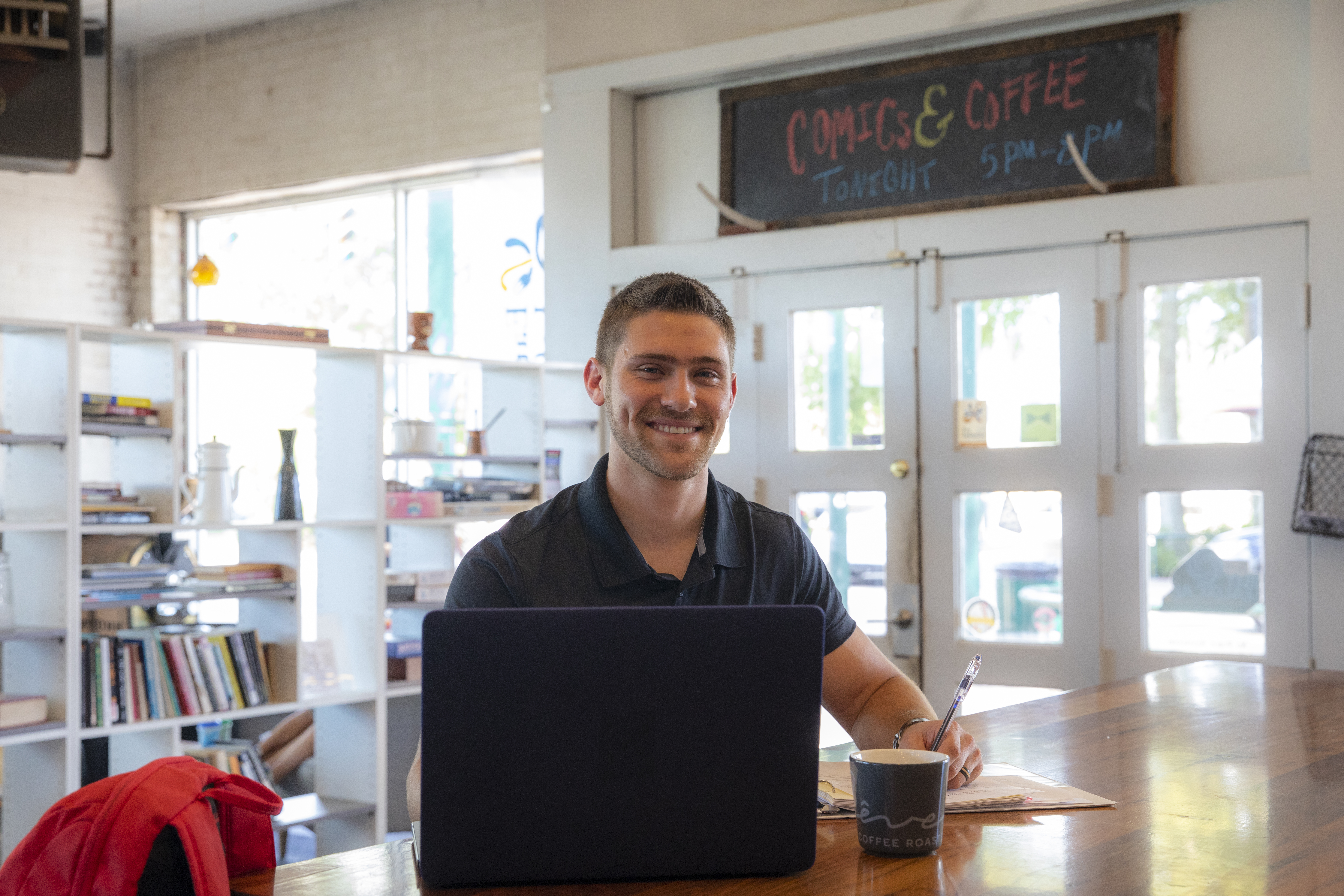 Ridge Leblanc sits with his notes and laptop at a local coffeeshop. Ridge earned both his bachelor's and MBA degrees from UL Lafayette.