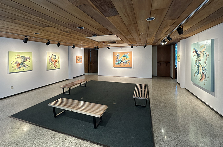 Art hangs on three walls with benches in the center of the Dean's Gallery