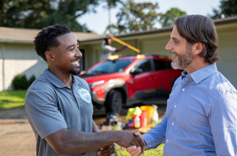 Online entrepreneurship graduate shakes hands with client after closing a deal. 