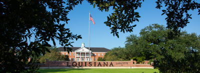 The UL Lafayette Louisiana Welcome Wall under a blue sky 