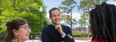 University of Louisiana at Lafayette alum David Begnaud interviews two students in front of Cypress Lake