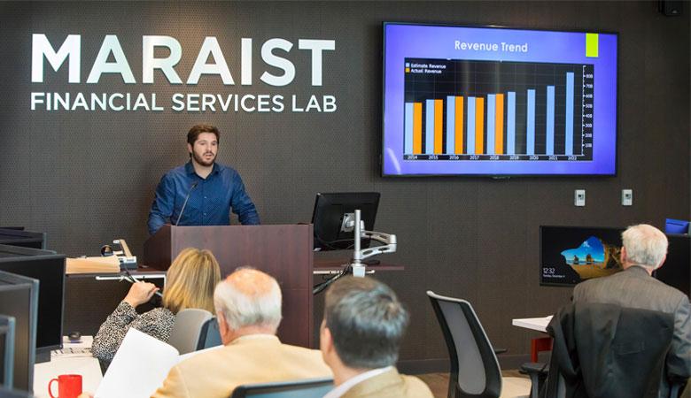 A University of Louisiana at Lafayette student presents a finance plan to a room of investors